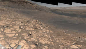 探測車在塵土飛揚的天空下探索裂開的岩石火星表面。 — 火星 壁紙