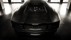 現代展示間中反射地板上的消光黑色藍寶堅尼Aventador。 — 蘭博基尼 壁紙