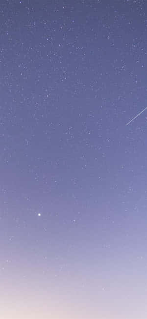 帶有紫色漸變和劃過流星的星空夜晚。 — iPhone 13 Mini 壁紙