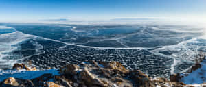 藍天下從雪岩觀看的冰凍湖面冰紋 — 湖泊 壁紙