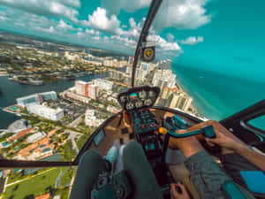 直升機機師飛越沿海城市，下方有海洋和建築物。 — 直升機 壁紙