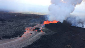 熔岩從火山流出，穿過黑暗的景觀，煙霧升騰。 — 煙動圖 壁紙