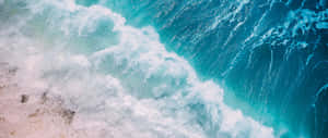 綠松石色的海浪拍打沙灘，泛起白色泡沫。 — 海洋 壁紙