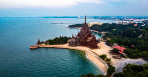 海灘半島上的木製寺廟，背景是海洋和城市 — 海灘 壁紙