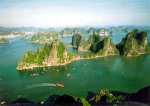 喀斯特島嶼從翠綠海水中升起，船隻在其間漂流。 — 尚氣 壁紙
