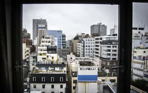 從窗戶俯瞰陰天下密集的日本城市景觀。 — 日式審美桌面 壁紙