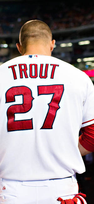棒球運動員Mike Trout穿著白色球衣，紅色27號，在夜間比賽中。 — Mike Trout 壁紙