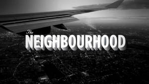 從飛機窗戶拍攝的鳥瞰圖，顯示夜晚的城市燈光，附有文字 The NEIGHBOURHOOD — 鄰里 壁紙