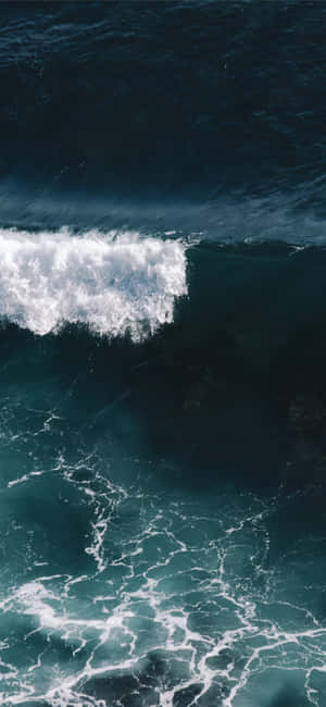 強勁的海浪在深藍色海面上翻湧，激起白色泡沫。 — Galaxy A56 壁紙