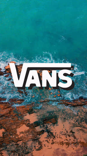 從上方俯瞰，Vans標誌疊加在拍打紅色岩石的海浪上。 — Vans 標誌 壁紙
