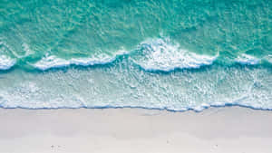 碧綠色的海浪輕輕湧上白色沙灘的俯瞰圖。 — 海灘 壁紙