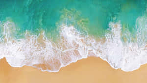 碧綠色的海浪從上方滾向金色沙灘。 — 海灘 壁紙