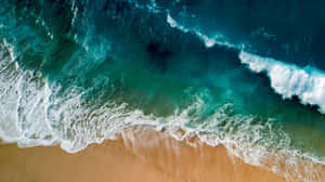 碧綠色的海浪在金色沙灘上破碎的鳥瞰圖。 — 自然 壁紙