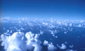 從上方看到的廣闊藍天，點綴著蓬鬆的白雲。 — 冬季風景 壁紙