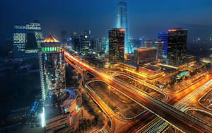夜晚的城市景觀，摩天大樓燈火通明，車流光軌閃爍。 — 唐人街 壁紙