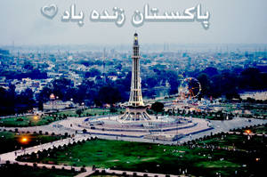 公園中的 Minar-e-Pakistan 紀念碑，摩天輪和背景的城市在暮色中。 — 巴基斯坦 壁紙
