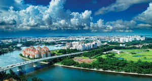 一座充滿活力的城市，擁有河流橋樑、綠色公園和上方戲劇性的雲彩。 — 美麗的夜晚 壁紙