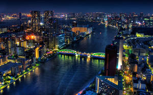 夜晚的城市，發光的建築物和水上亮燈的橋樑。 — 東京 壁紙