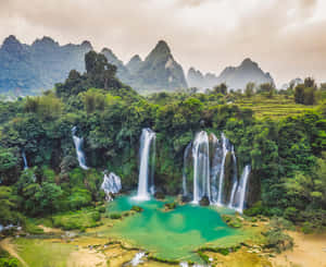 瀑布傾瀉入茂密叢林和高山中的碧綠色水池。 — 湖泊 壁紙