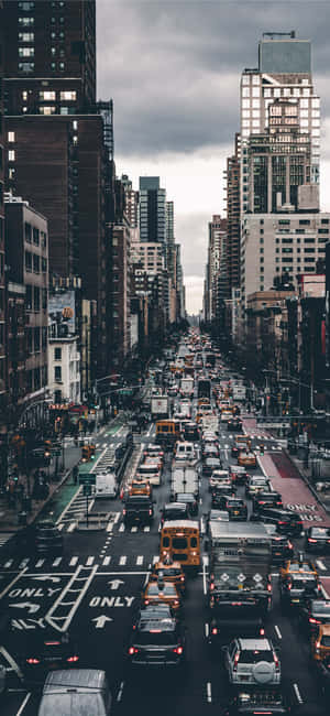 繁忙的城市街道，充滿汽車和高樓大廈，天空多雲。 — 紐約 壁紙