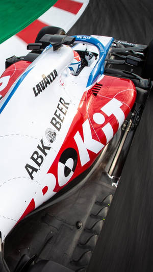 帶有贊助商標誌的 Formula 1 賽車在賽道上飛馳 — 運動 壁紙