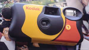 復古Kodak即時相機，黃色、黑色和紅色設計。 — 1600x900 壁紙