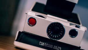 復古白色Polaroid SX-70相機，帶紅色快門按鈕和鉻色細節。 — 拍立得 壁紙