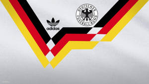 帶有黑、紅、金色條紋和Adidas標誌的德國國家足球隊球衣。 — 復古90年代風格 壁紙