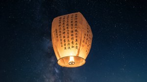 一盞寫著心願的燈籠飄向星空，象徵著願望的寄託。