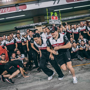 愛快羅密歐F1車隊在車庫中以歡呼和擁抱慶祝P6頒獎台成績。 — 手機 壁紙