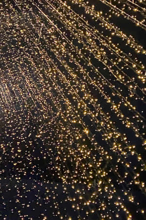 在黑暗的夜空背景下發光的金色仙女燈對角線串。 — Huawei MatePad 11.5 S (2025) 壁紙