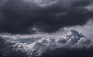 戲劇性的暗色風暴雲與下方明亮的白色雲朵 — 2880x1800 壁紙