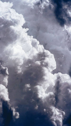 在深藍色天空的襯托下，密集的白雲帶有深色陰影。 — 雲朵 GIF 壁紙