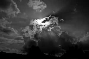 陽光穿透烏雲，照耀在剪影般的風景上。 — 簡約暗黑美學 壁紙