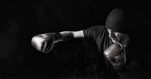 戴毛帽的拳擊手在煙霧瀰漫的昏暗工作室中揮拳 — 拳擊 壁紙
