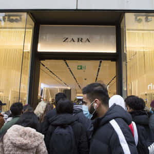 穿著冬季外套和口罩的人們在 Zara 服裝店外排隊。 — Zara 壁紙