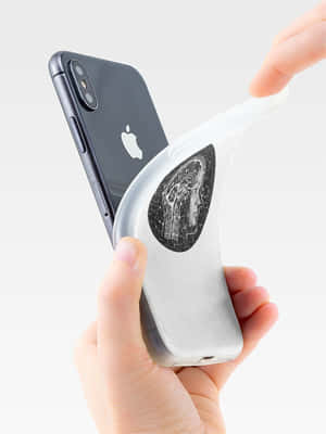 手拿著iPhone，配備透明保護殼，帶有黑色天體頭部設計。 — 機器人 壁紙
