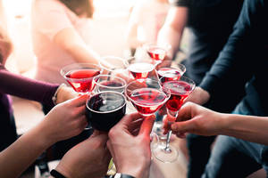 一群人在溫暖的燈光下用酒杯和雞尾酒杯祝酒。 — 慶祝 壁紙