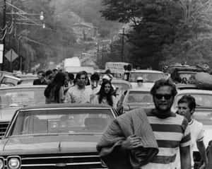 抗議期間，繁忙街道上的人群和古董車。 — Woodstock 壁紙