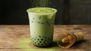 抹茶泡泡茶，撒上抹茶粉，搭配竹製茶筅。