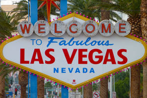 歡迎來到 Fabulous Las Vegas Nevada 標誌，背景有棕櫚樹和城市交通。 — 拉斯維加斯 壁紙
