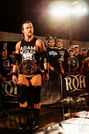 摔角手 Adam Cole 在摔角擂台上帶著冠軍腰帶行走。 — 摔角 壁紙