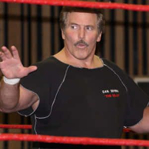 摔角手 Dan Severn 在擂台上穿著黑色襯衫，紅色繩索清晰可見。 — 終極格鬥冠軍賽 壁紙
