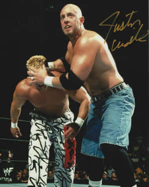 摔角手 Justin Credible 在 WWE 擂台上將對手壓制，背景有觀眾。 — 4:5 壁紙