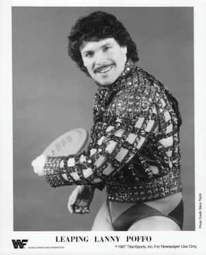 摔角手 Lanny Poffo 穿著閃亮服裝在攝影棚照片中拿著飛盤。 — 運動 壁紙