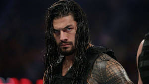 摔角手 Roman Reigns 濕頭髮和刺青在黑暗的競技場中。 — 羅曼·雷恩斯 壁紙