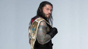摔角手 Roman Reigns 佩戴冠軍腰帶和黑色裝備，身上有紋身。 — 羅曼·雷恩斯 壁紙