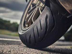 陰天下瀝青路上的摩托車輪胎 — 弗萊克斯·惠勒 壁紙