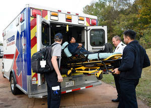 救護人員在樹林地區將病人送入救護車。 — 工作 壁紙