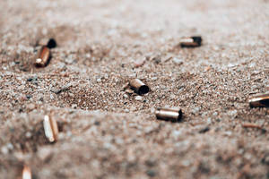 黃銅彈殼散落在沙地上 — 射擊 壁紙
